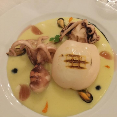 Seppia grigliata su crema di patate con gocce di nero di seppia e gelatina di vino rosato